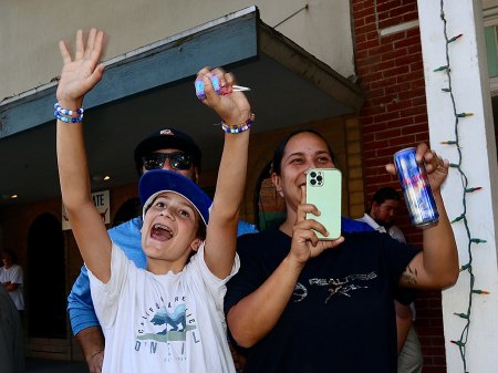 Spectators wave as Lemoore High School's Homecoming Parade traverses the downtown.